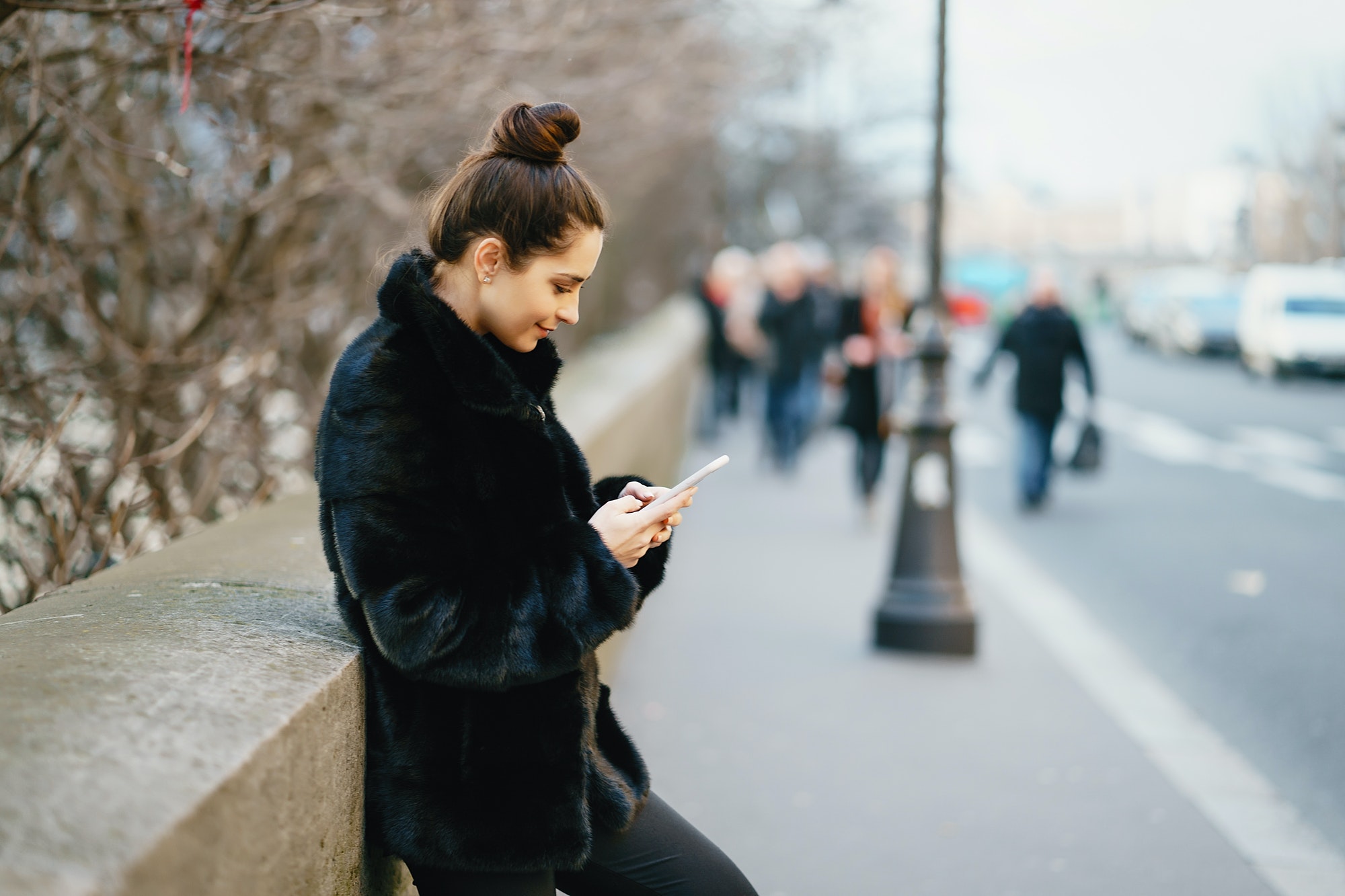 woman using her cell phone while walking through Paris